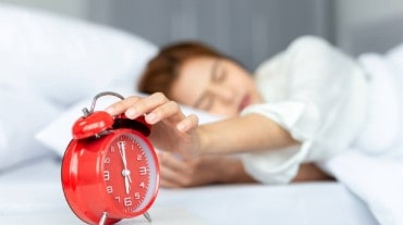 Woman sleeping with an alarm clock