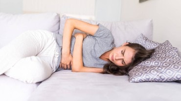 A woman pressing her stomach