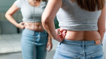 A woman looking at her belly fat