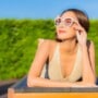 A woman with psoriasis relaxing around outdoor swimming pool