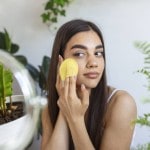 A girl applying a skin care product on her face